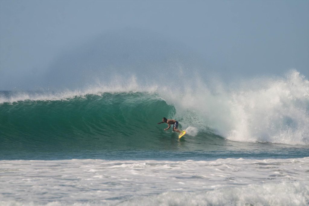 a surfing cought a beautiful wave in Tamarindo beach Costa Rica